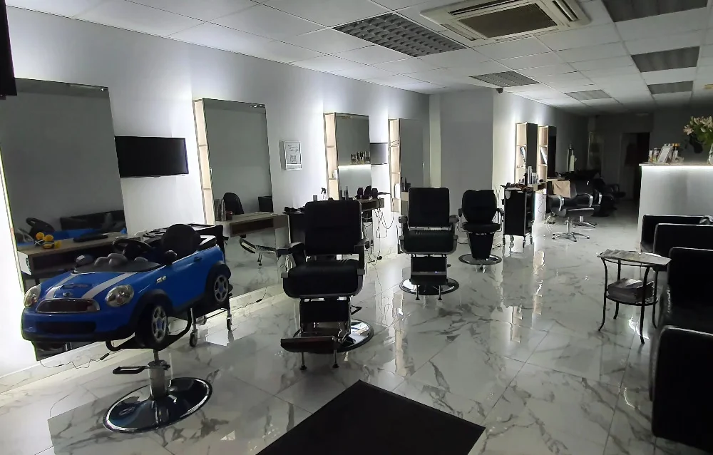 Wnętrze salonu fryzjerskiego z fotelami i strefą recepcji